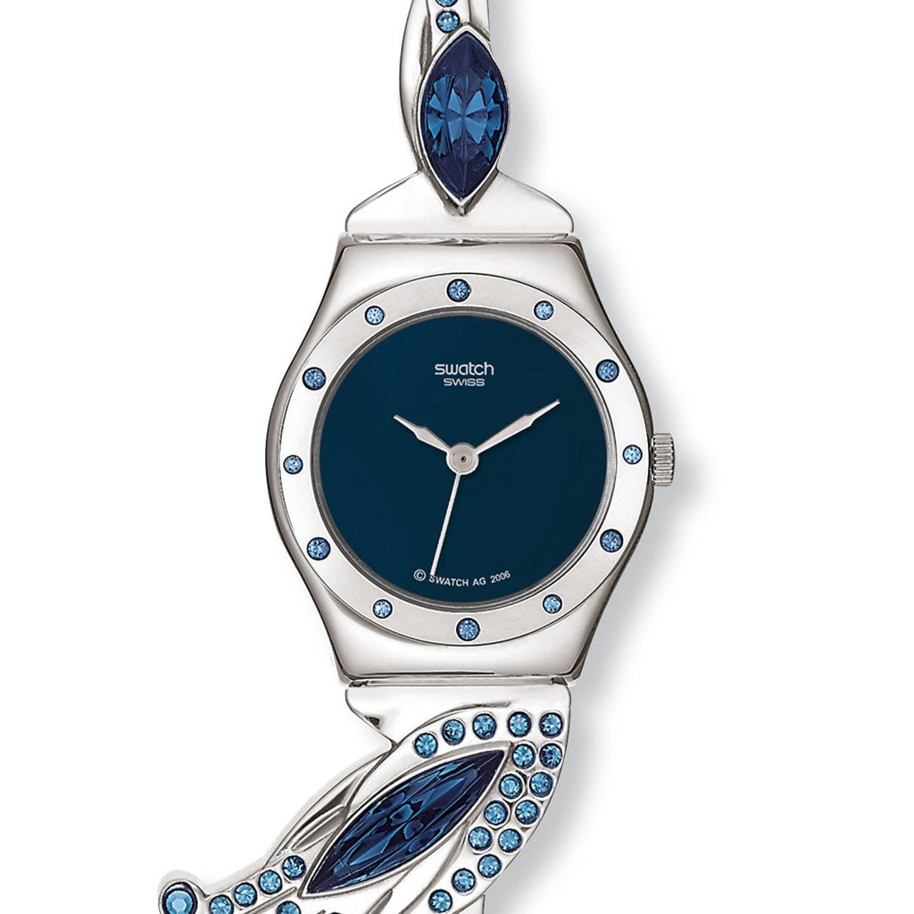 Die Swatch GLAMFLASH ist eine kleine Damenuhr, die in den Farben Blau und Silber gehalten ist. Das Gehäuse, auf dem 12 Kristalle eingefasst sind, und das Armband sind aus Edelstahl, dieses kann in der Länge beliebig gekürzt werden. Am Bandansatz sind stil